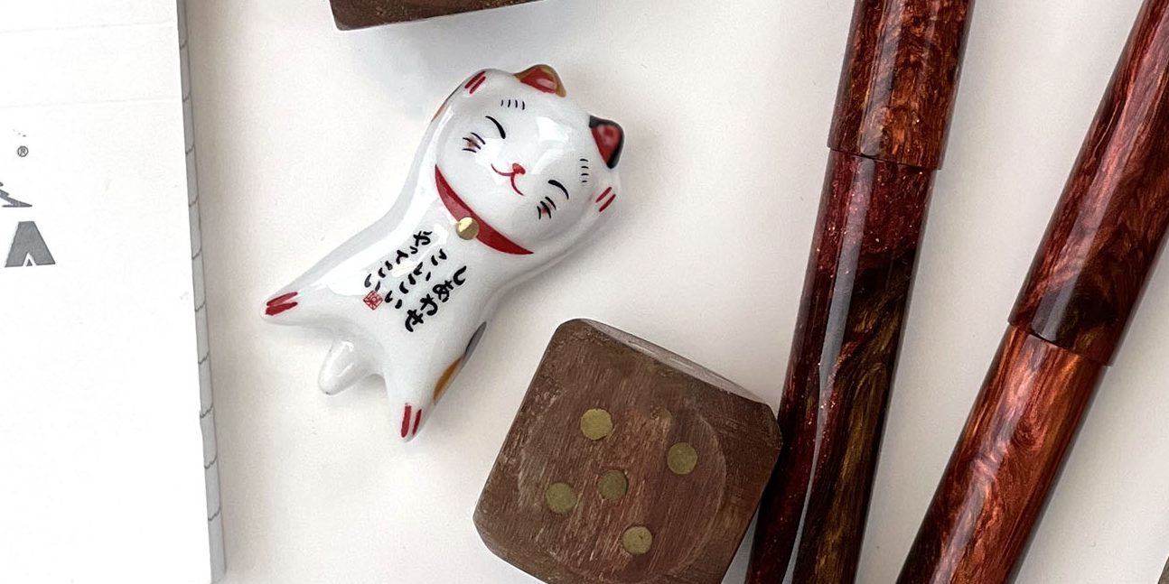 The Undefeated Lucky Cat pen rest (a new product release for 2022 Q1) is seen here alongside an Exclusive Hinze Pen (one of our new 2022 fountain pen brands).