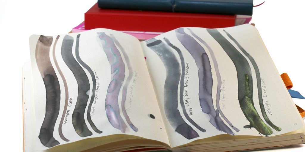 Grey shimmer ink comparison showing swatches of six inks side-by-side in a Rhodia Goalbook notebook.