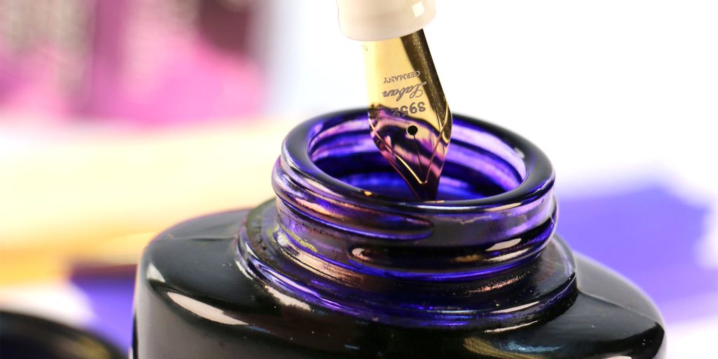 The wide mouth of the Private Reserve Ride the Lightning ink bottle with a Laban nib dipping inside. 