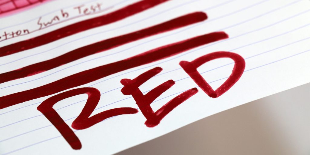 Cotton swab test showing deep red J. Herbin Rouge d’Orient ink on lined paper.