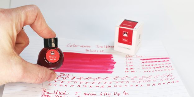 Colorverse Felicette Ink Review test sheet with a hand holding the mini 5ml ink bottle and the ink box in the background.