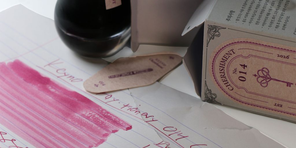 Keyno 014 Cherishment ink packaging with Room No. insert, ink drop shaped 25ml ink bottle, and pink fountain pen ink test sheet behind.