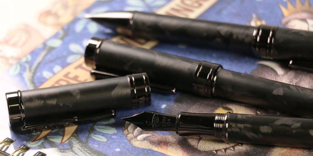 Conklin Endura Forged Carbon Fiber writing instruments with black forged carbon fiber finish, black trim, and fountain pen nib.