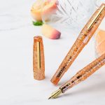 BENU Cocktail Hour Bellini fountain pen with warm peach-orange resin and sparkling cocktail-inspired accents.