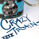 Private Reserve Crazy Train turquoise gold shimmer fountain pen ink bottle with a bold blue handwritten ink swatch.