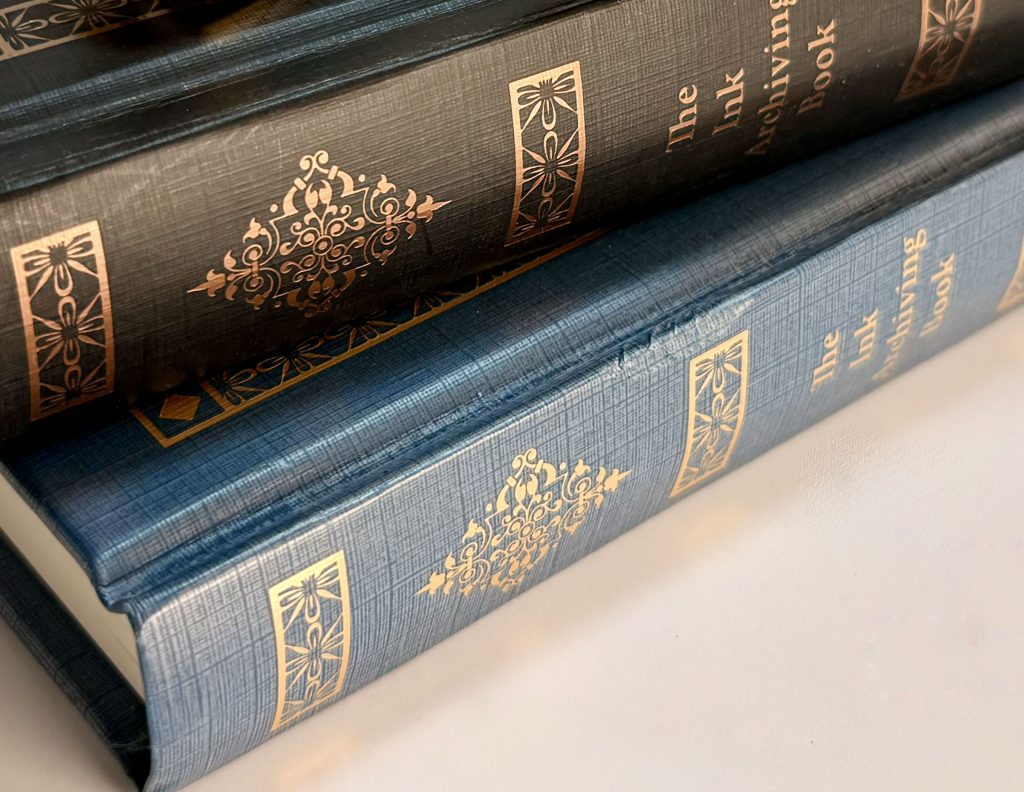 Dominant Industry Ink Archiving Books in black and blue with textured covers and metallic gold decorative details.