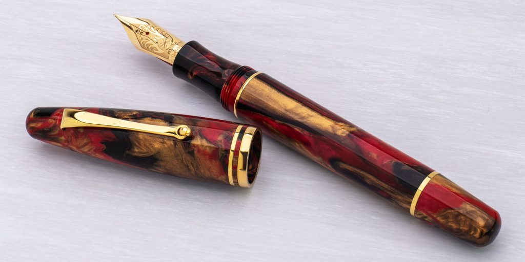 Photo of the Delta Ultra Ogiva Golden Rule 14kt gold nib fountain pen uncapped showing the exquisitely crafted nib.