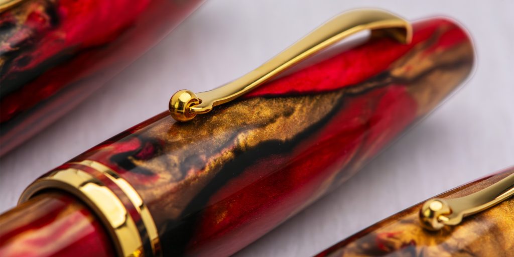 Closeup of the cap and pen clip of the Delta Ultra Ogiva Golden Rule 14kt gold nib fountain pens