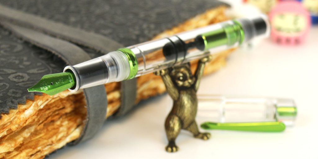 Nahvalur Spring Original fountain pen uncapped and held up by the Sassy Brassy Cat pen rest.