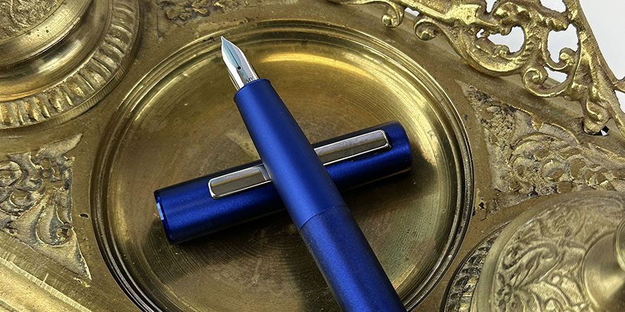 lamy_aion_fountain_pen_dark_blue_gold_antique_inkwell_in_background