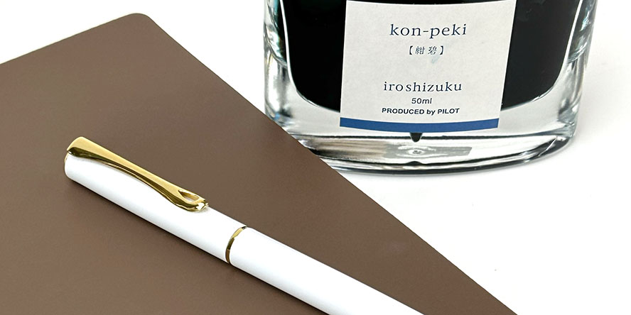 diplomat_traveller_white_fountain_pen_with_gold_trim_and_pineider_blues_notebook