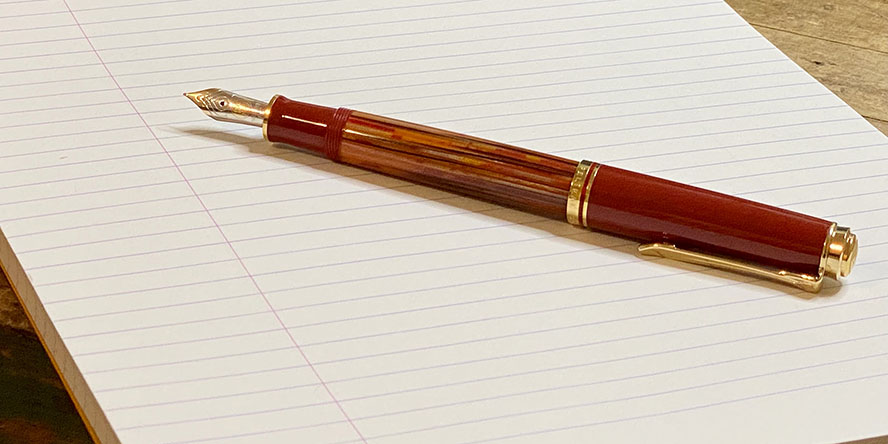 pelikan_m600_tortoiseshell_red_fountain_pen_posted_on_lined_paper