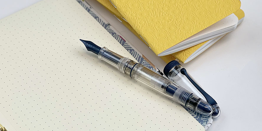 aurora_888_trilobiti_blue_cobalt_fountain_pen_uncapped_with_signs_of_spring_field_notes